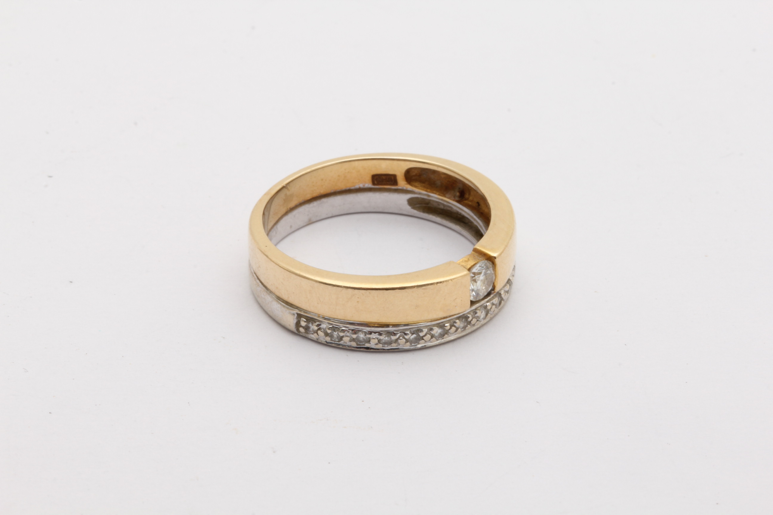 RING I TVÅ-FÄRGAT GULD MED DIAMANTER TOT. CA: 0,20CT, MITTSTEN CA: 0,12CT, ø 18MM – TILLV. GULDFYNDGRUPPEN